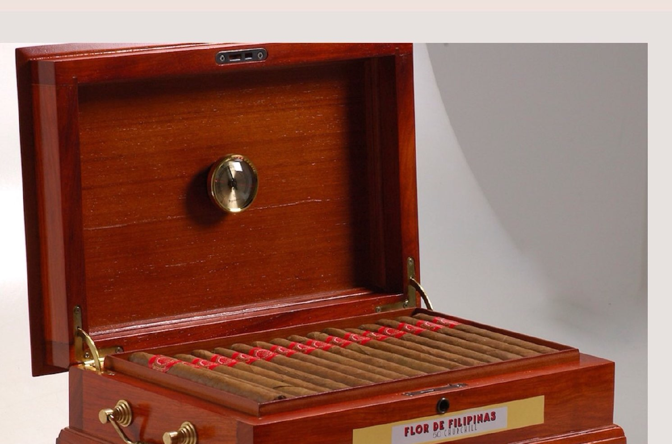 Open wooden humidor box with rows of cigars